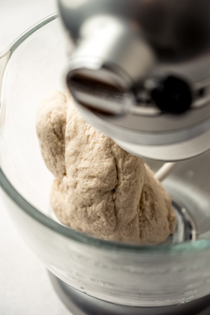 Bagel dough in the bowl of a stand mixer.