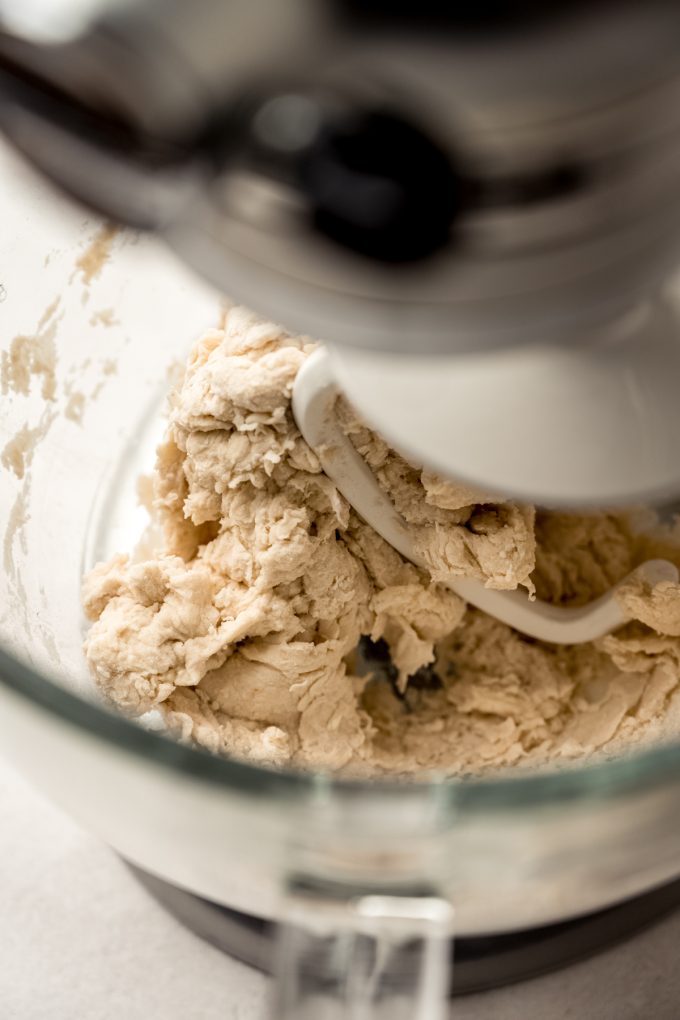 Bagel dough in the bowl of a stand mixer.