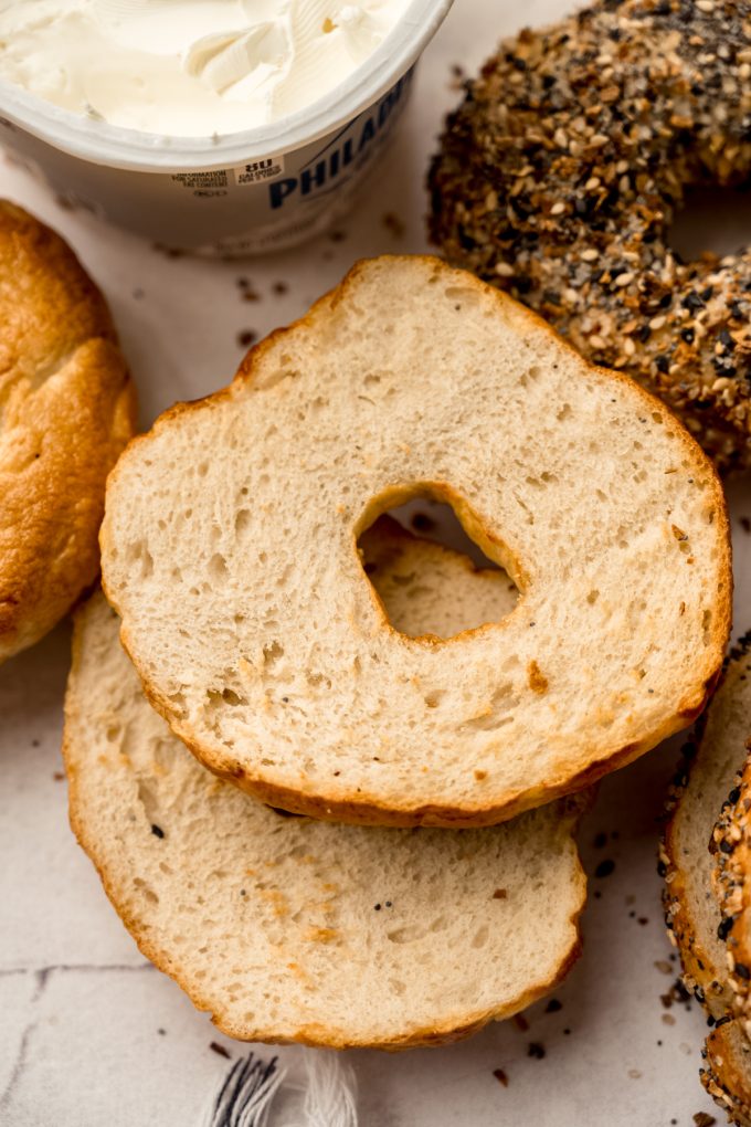 A homemade bagel that has been sliced and toasted on s surface.