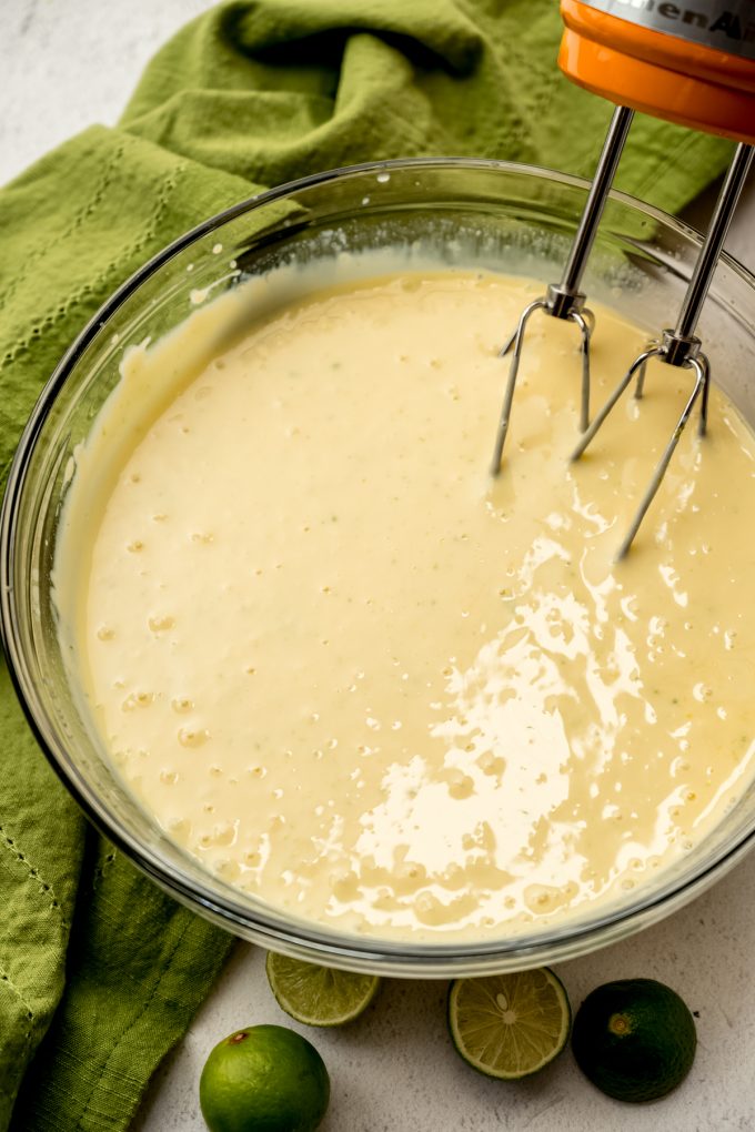 The filling for Key lime pie in a bowl with electric beaters.
