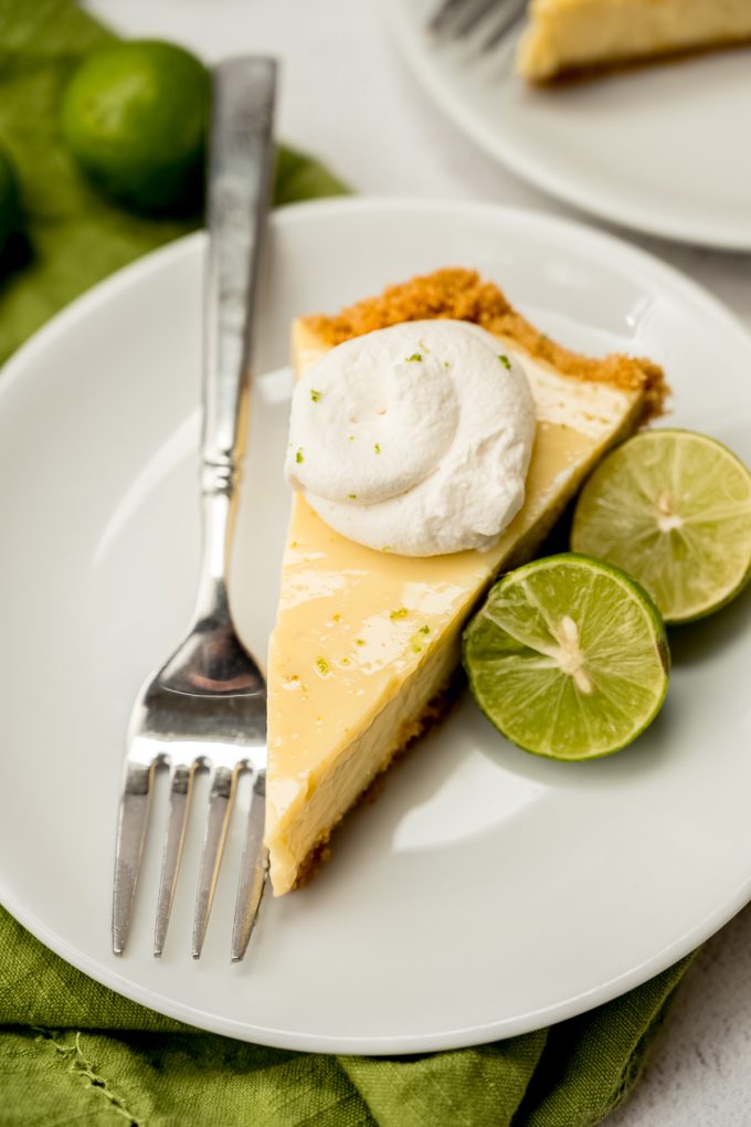 A photo of a slice of Key lime pie on a plate with a fork.