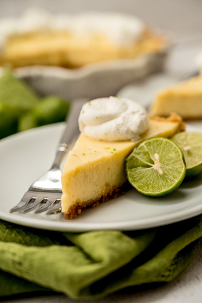 A photo of a slice of Key lime pie on a plate with a fork.