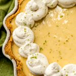 A Key lime pie dolloped with whipped cream.