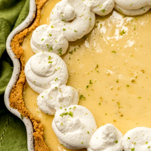 A Key lime pie dolloped with whipped cream.