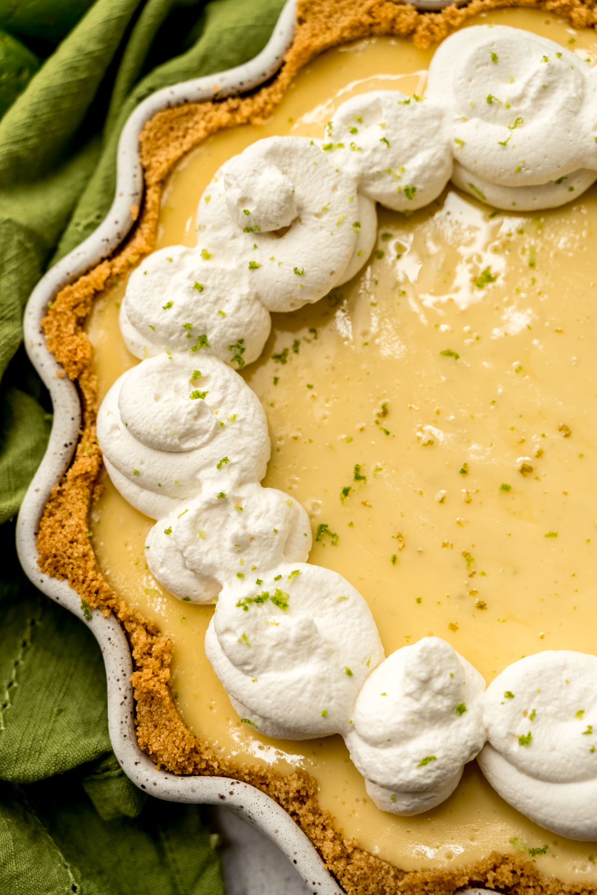 A Key lime pie dolloped with whipped cream.
