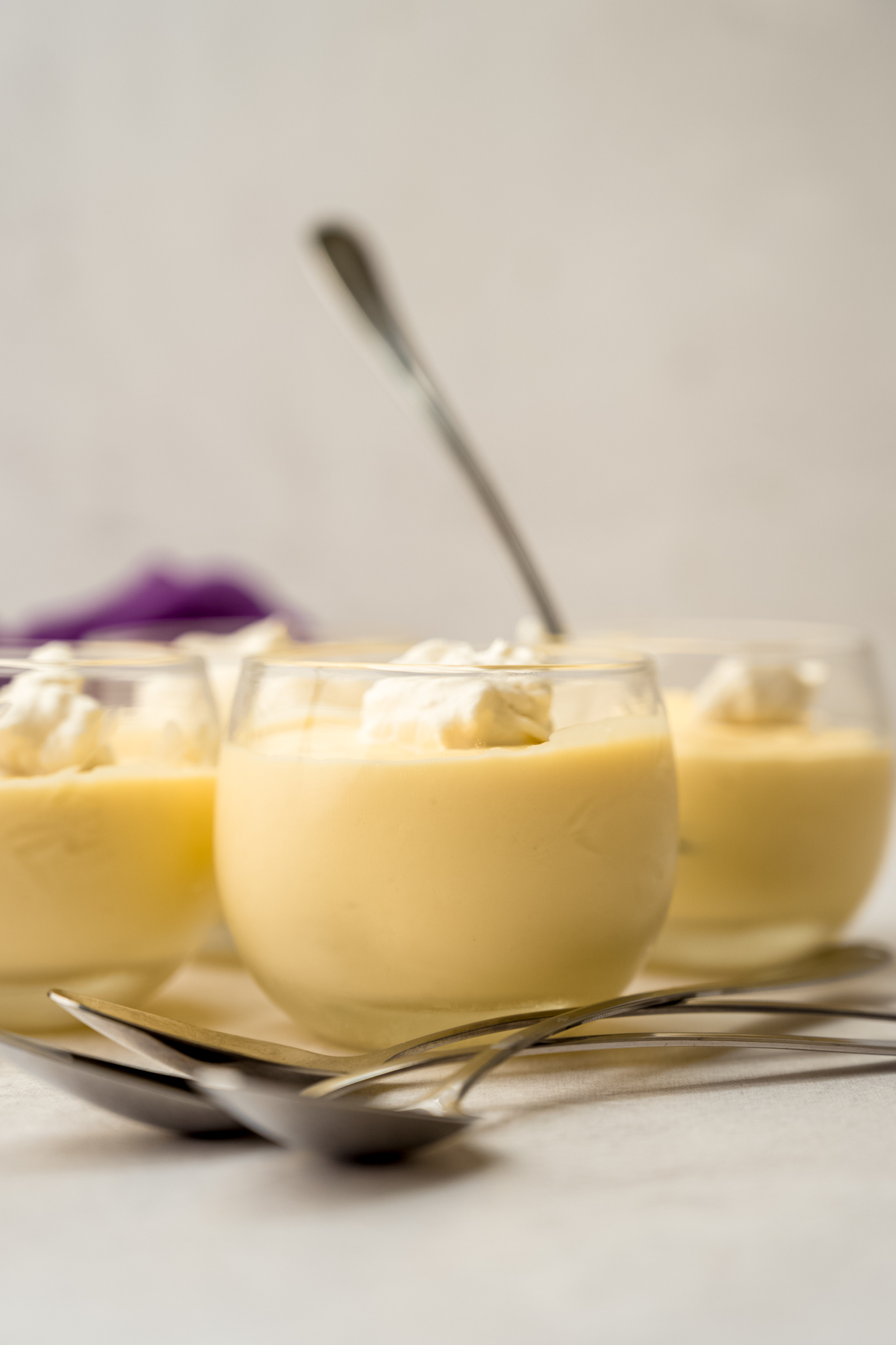 Dessert cups of passion fruit mousse on a surface.