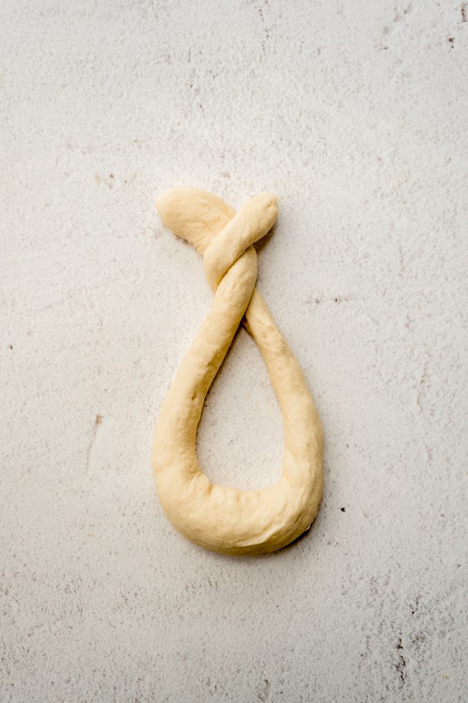 A rope of dough shaped into the first stage of a pretzel shape.