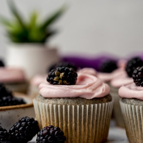 A blackberry cupcake on a surface.