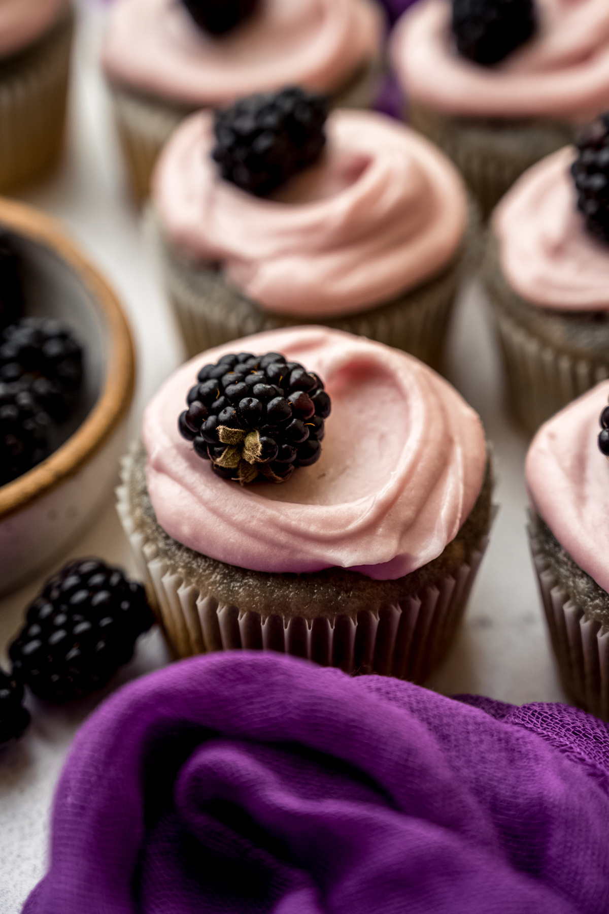 Blackberry cupcakes on a surface.