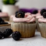 Blackberry cupcakes on a surface.