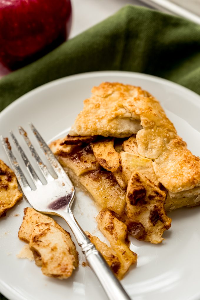A slice of apple galette on a plate with a fork.