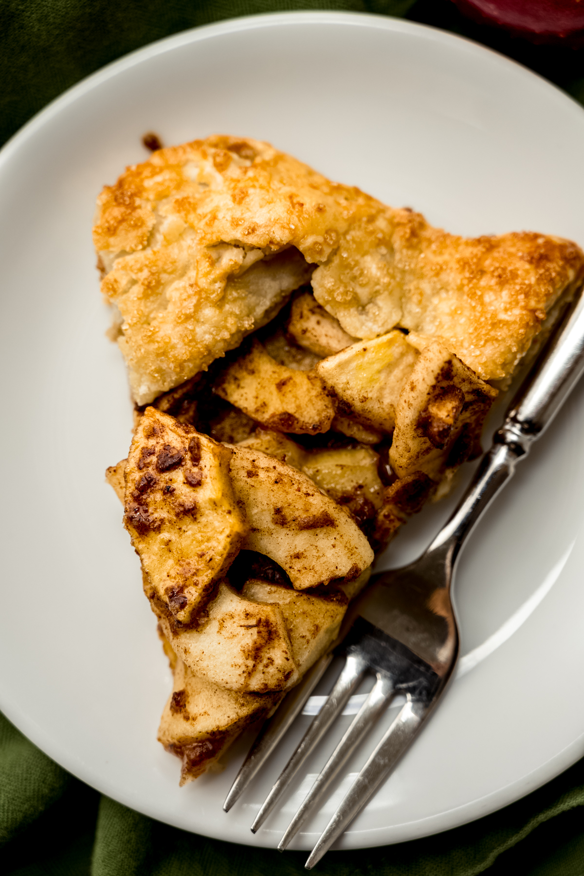 A slice of apple galette on a plate with a fork.