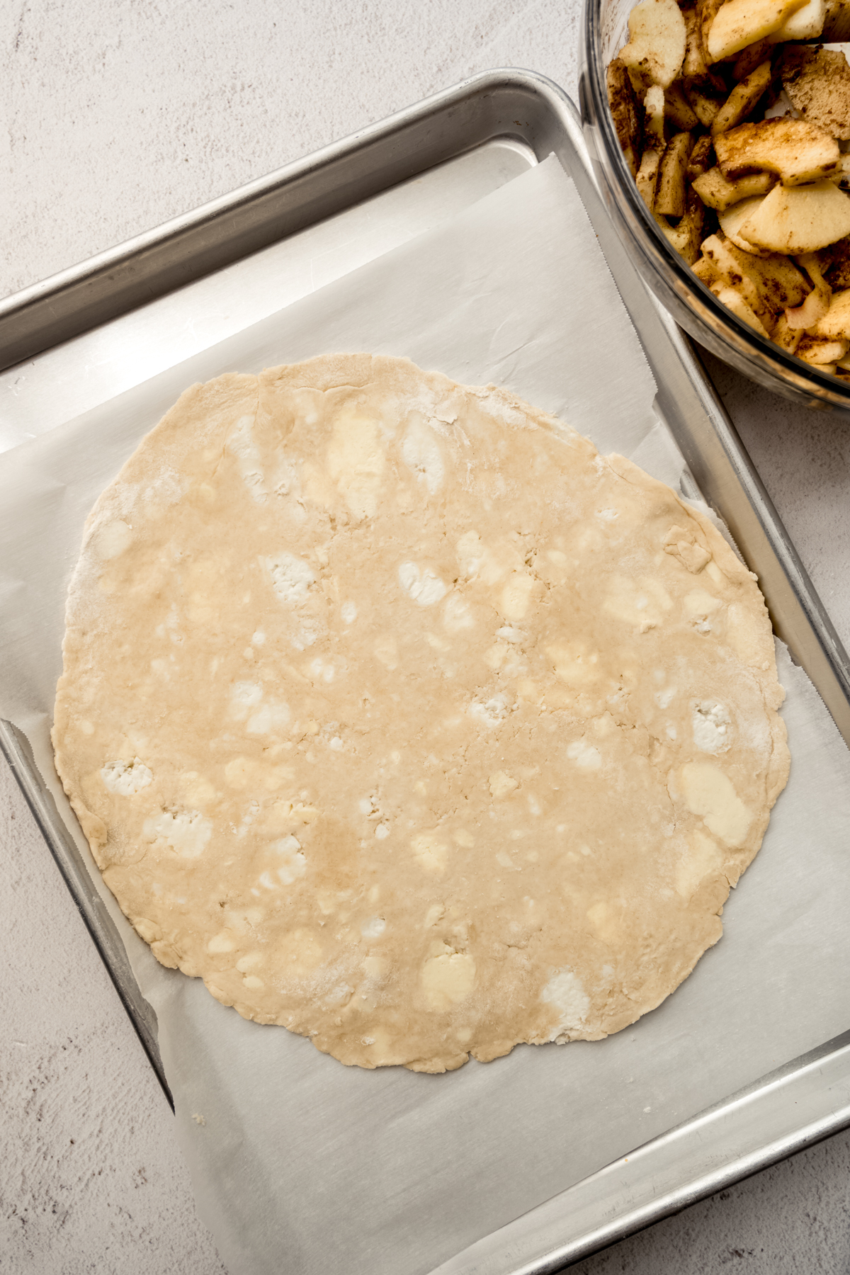 A baking sheet with a pie dough rolled out onto it.