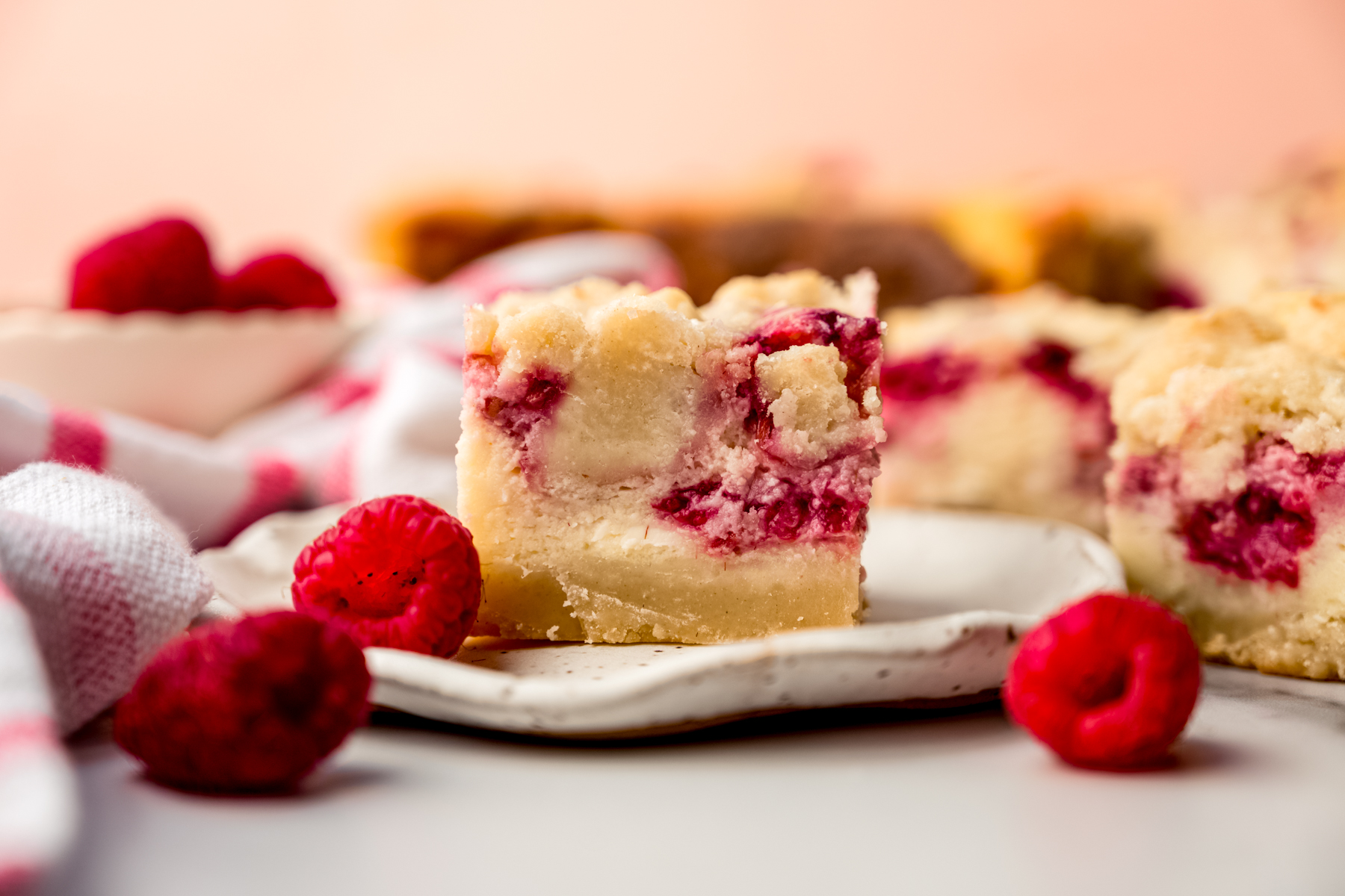 A raspberry cheesecake bar on a plate.