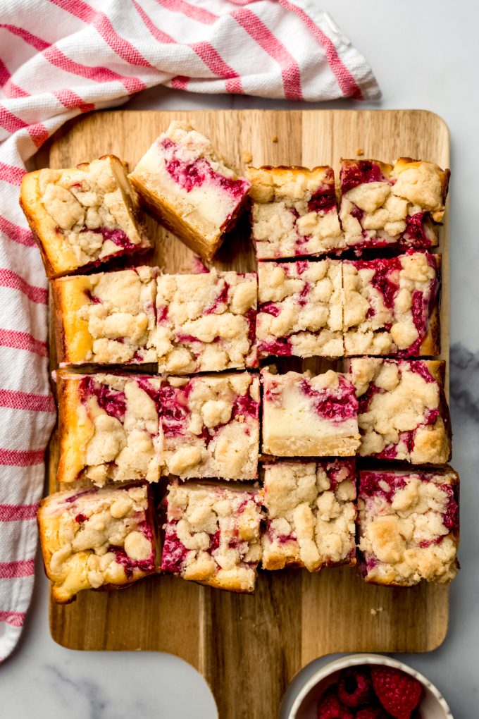 Aerial photo of raspberry cheesecake bars on a cutting board.